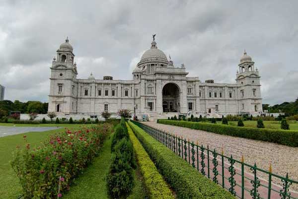 Front view of the Victoria Memorial in Kolkata, India, with manicured gardens and cloudy skies.