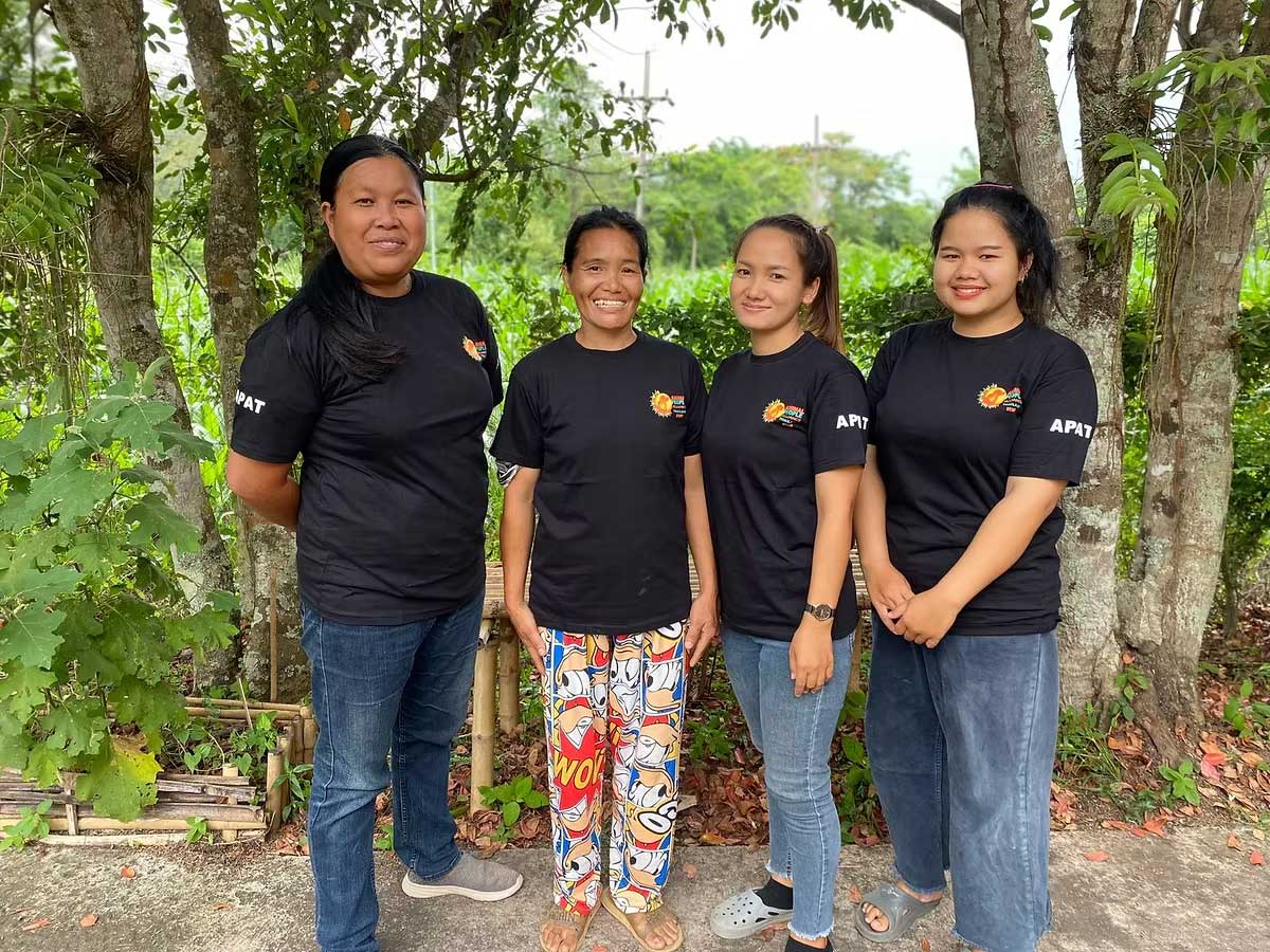 Four Animal People Alliance Thailand team members standing together outdoors, smiling and wearing matching black APA shirts.